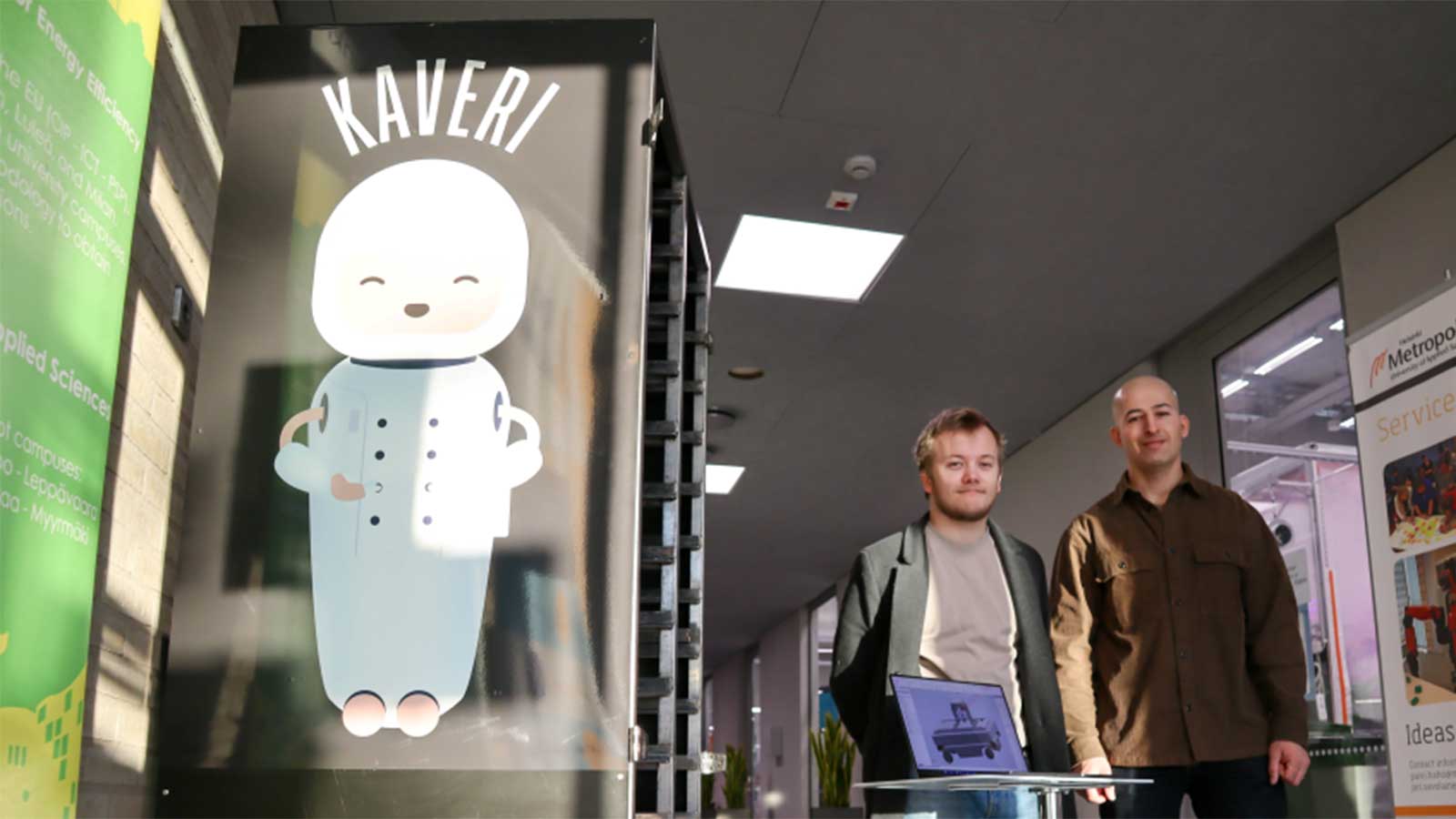 Kaveri-robotti ja kaksi opiskelijaa Myyrmäen kampuksen käytävällä.