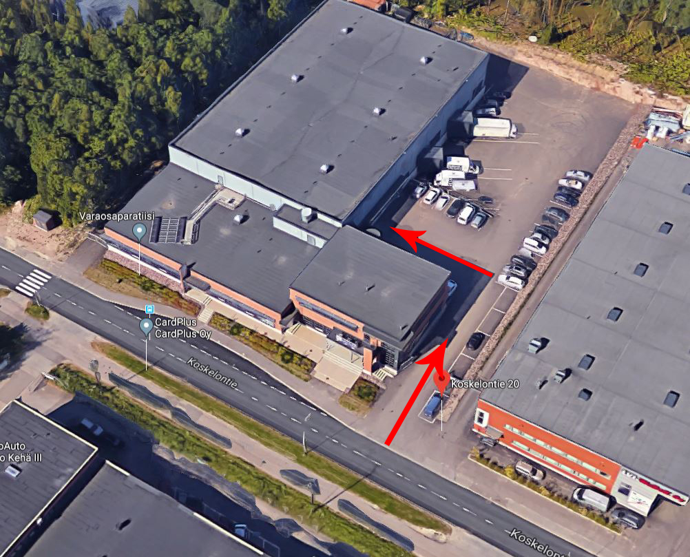 Koskelontieltä käännytään kahden rakennuksen välistä Koskelontie 20:n pihaan. Sisäänkäynti on vasemmalla. 