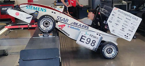 Formula student race car's center of gravity being measured by lifting front wheels up with a car lift.
