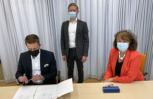 Ossi Koskinen, Jarno Eskelinen ja Riitta Konkola allekirjoittavat sopimuksen.