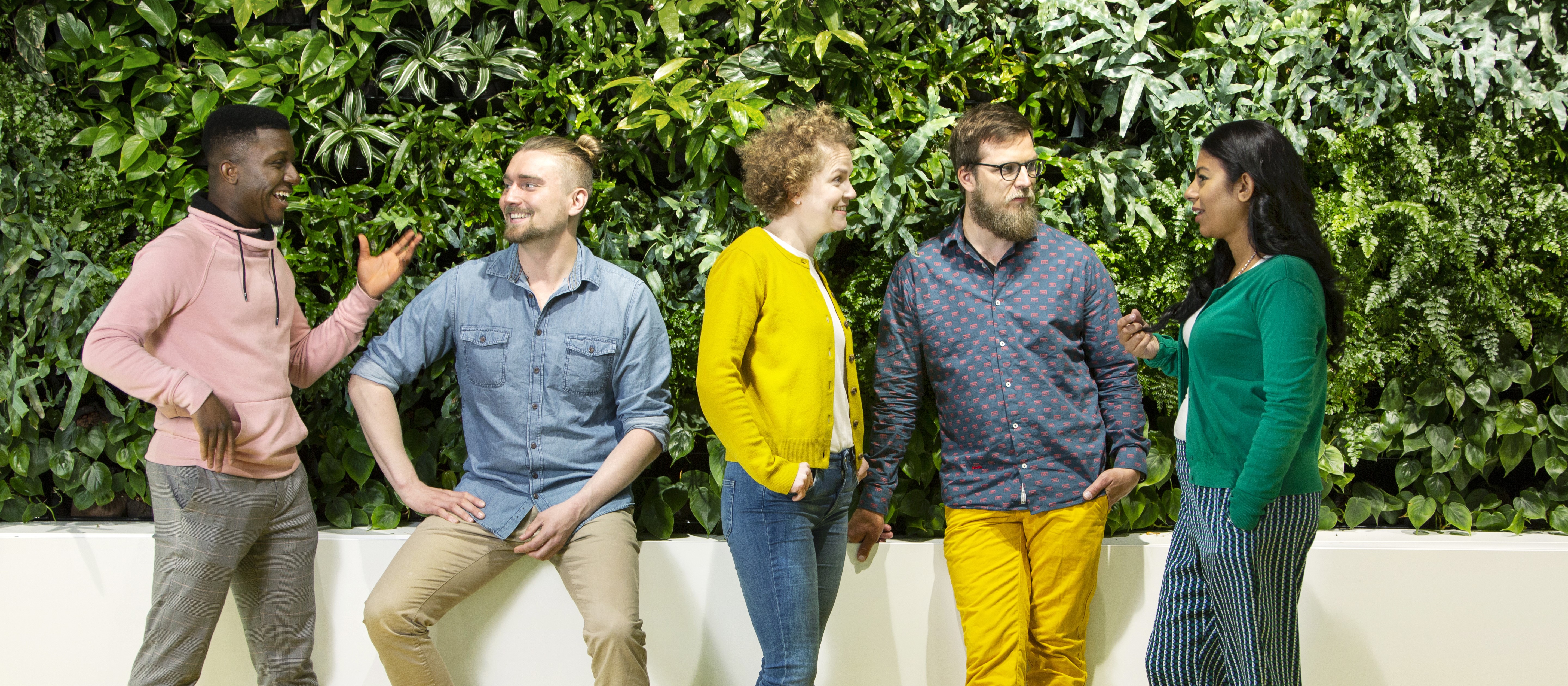 Five people chatting indoors happily