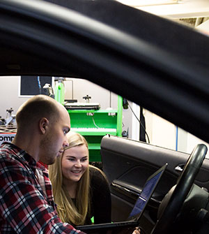 Opiskelijat tarkastelevat auton ajotietokoneen tietoja kannettavalta tietokoneelta.
