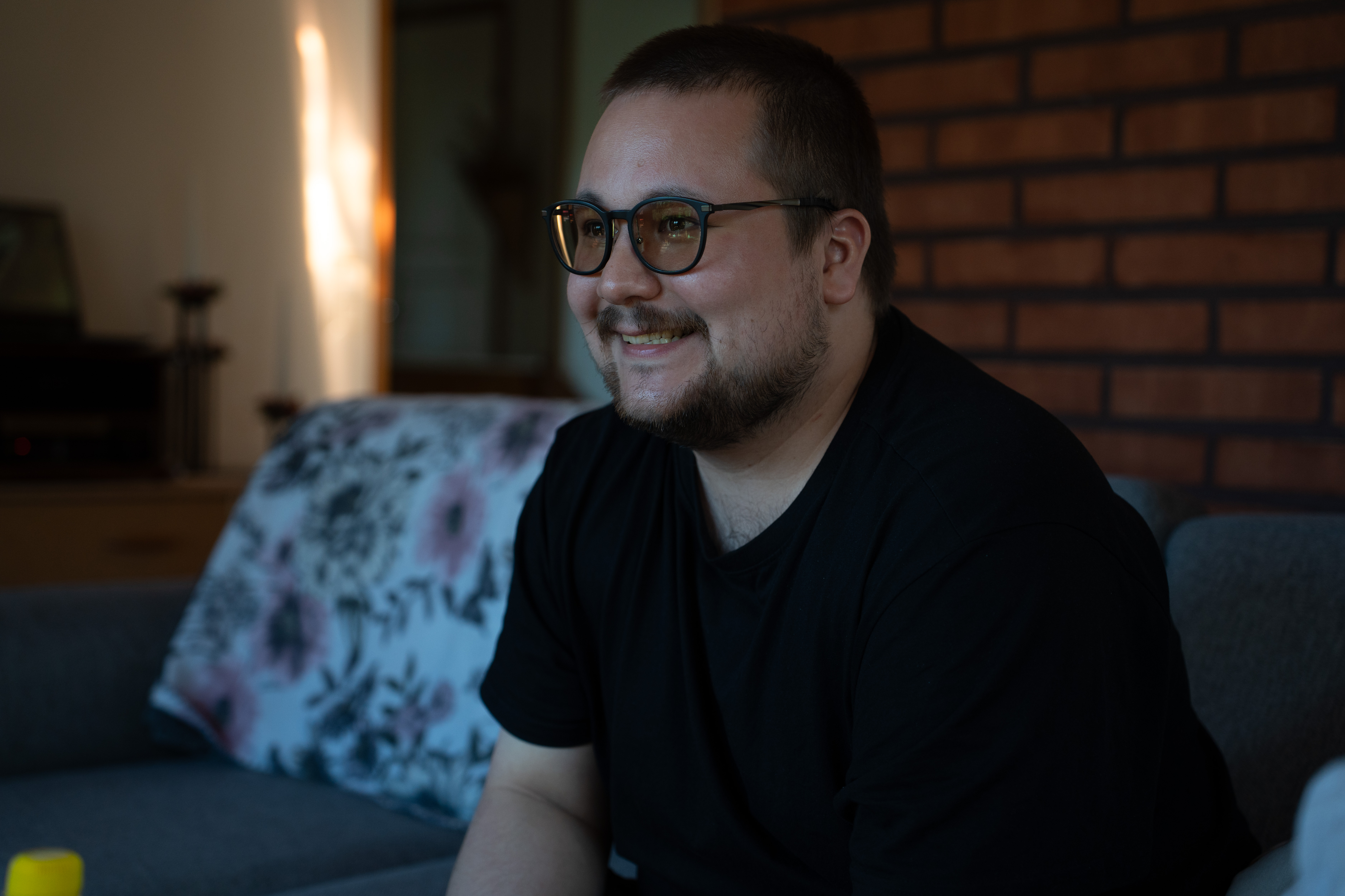 Opiskelija Akira poseeraa sohvalla
