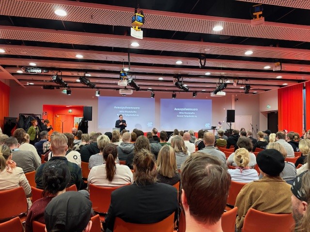 Ihmisiä kuuntelemassa puheenvuoroa tapahtumasalissa