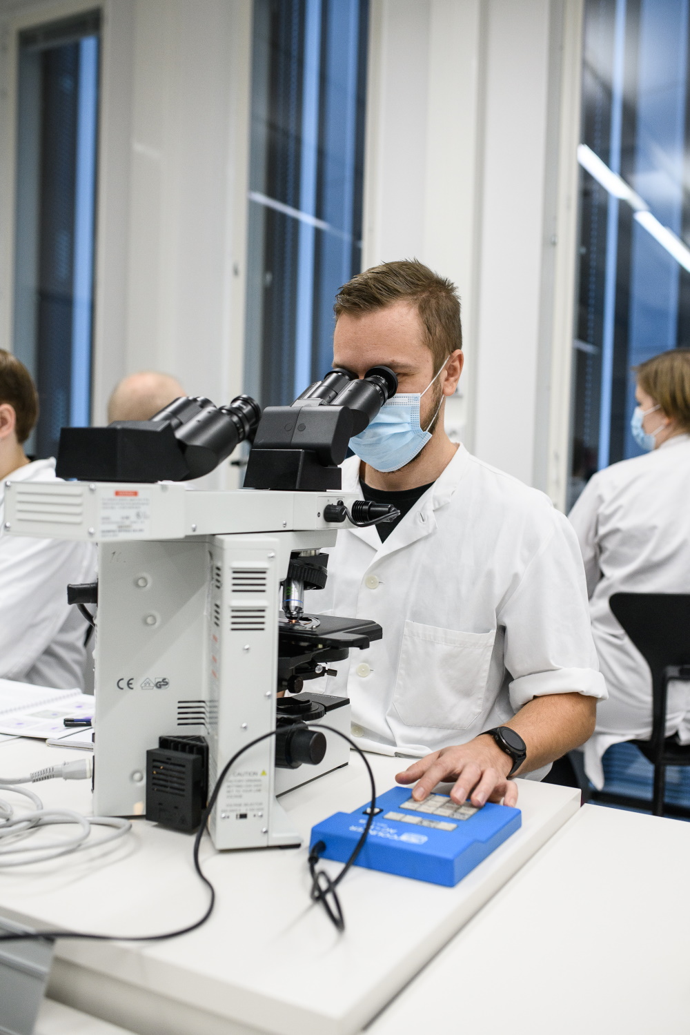 Bioanalytiikan opiskelija katsoo mikroskooppiin laboratoriossa