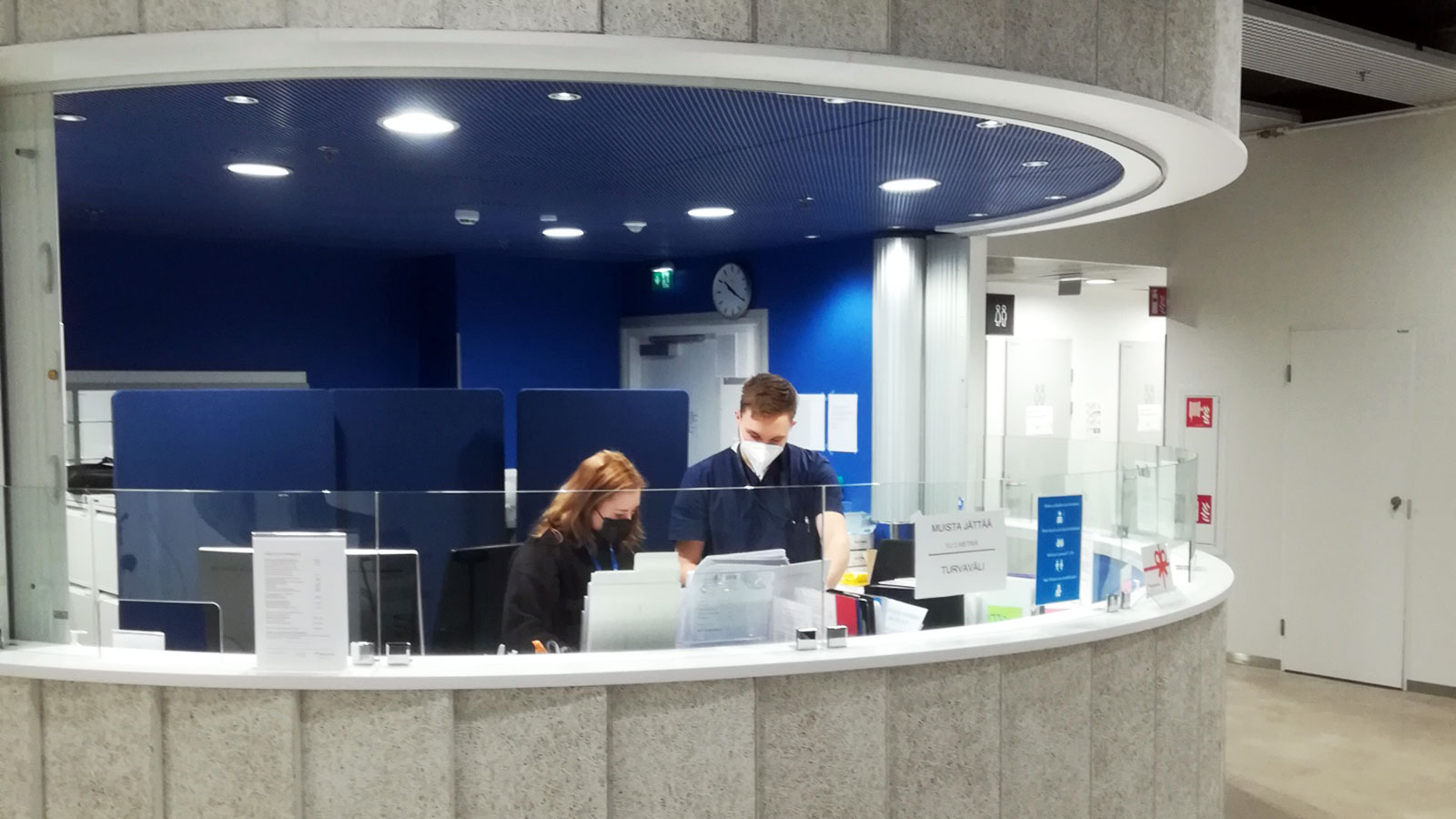 HyMy-village reception desk, two students behind it.