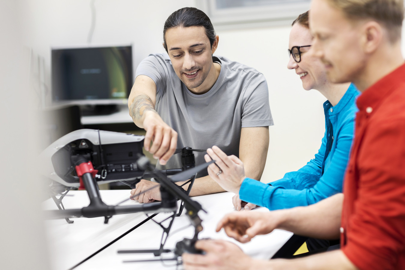 Three students around a drone.