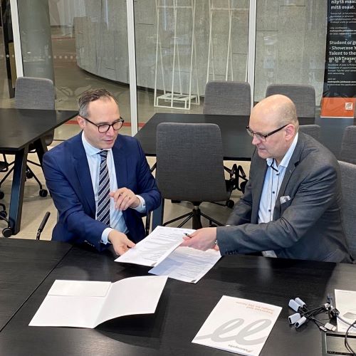 Tatu Järvenpää ABB:ltä ja Simo Mustila Metropoliasta istuvat pöydän ääressä allekirjoittamassa yhteistyösopimusta.
