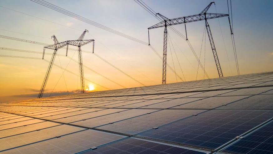 Sähkökaapelit ja aurinkokennot auringonlaskussa