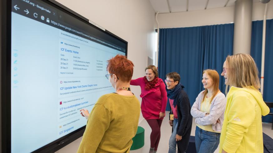 Five people in front of smart screen