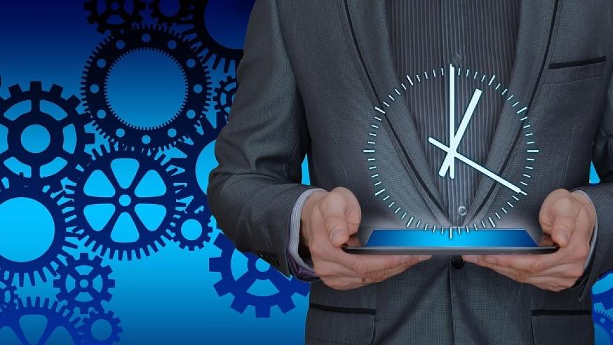 Piirrettyjä kellokoneiston osia, piirretty ihmishahmo jostan näkyvillä vain torso harmaassa puvussa, pitelee käsissään viisarikelloa