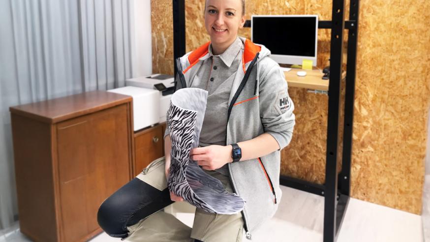 henkilö istuu 3D printattu proteesi kädessään