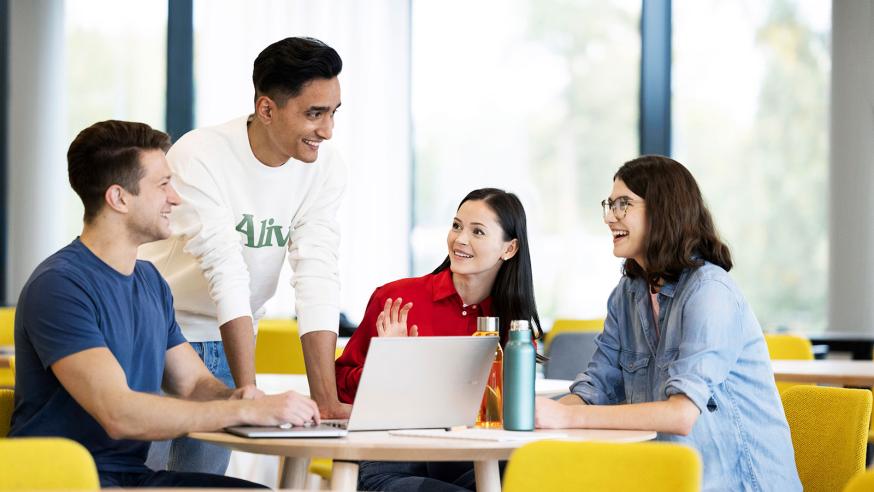 Four students discussing around a table.