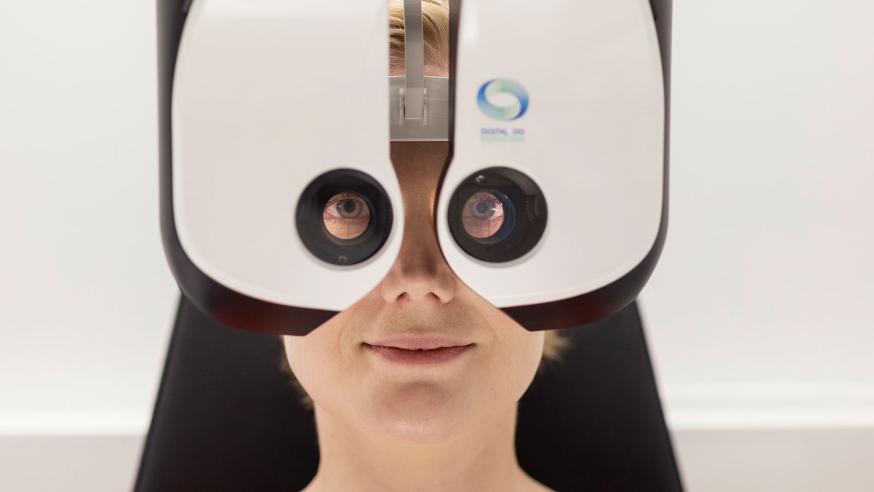 Opiskelija testaa asiakkaan roolissa optometrian laitetta.