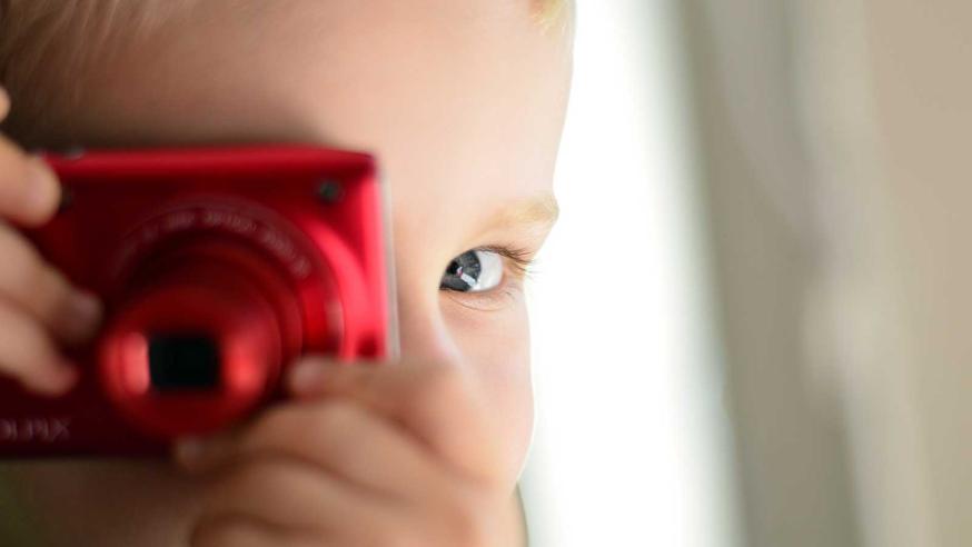 Lapsi ottaa kuvaa kameralla.