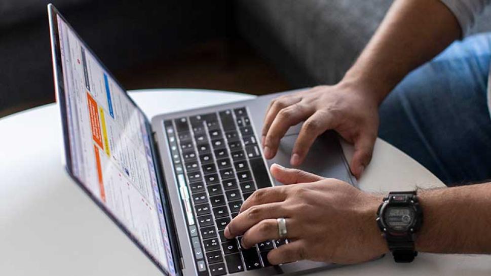 Fingers on a laptop keyboard.