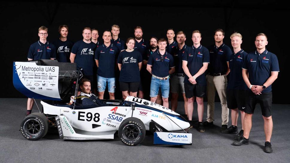 Opiskelijatiimi ja heidän rakentamansa sähköformula.