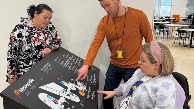 Three people looking at a campus map.