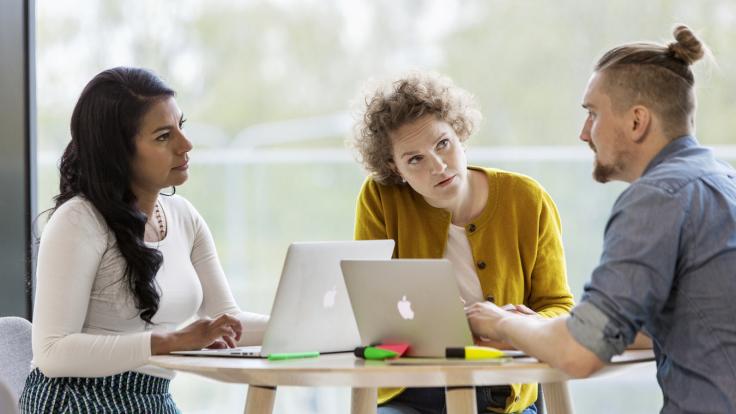 Three persons discussing.