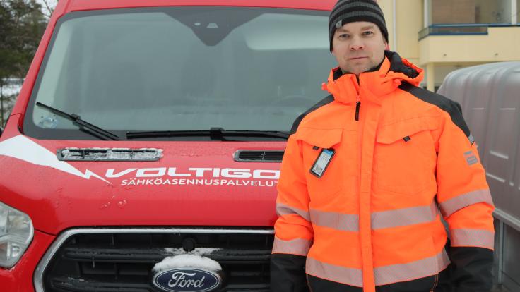 Voltigon työntekijä poseeraa auton edessä