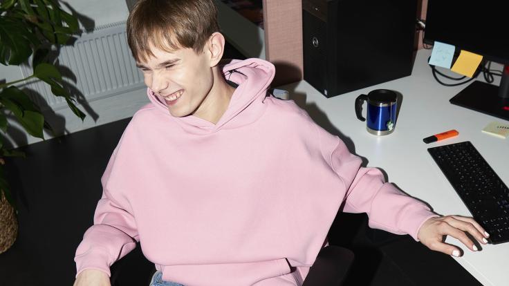 Opiskelija poseeraa koneen ääressä