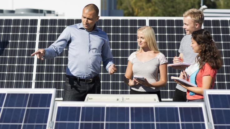 Aurinkopaneeleja ja ihmisiä.