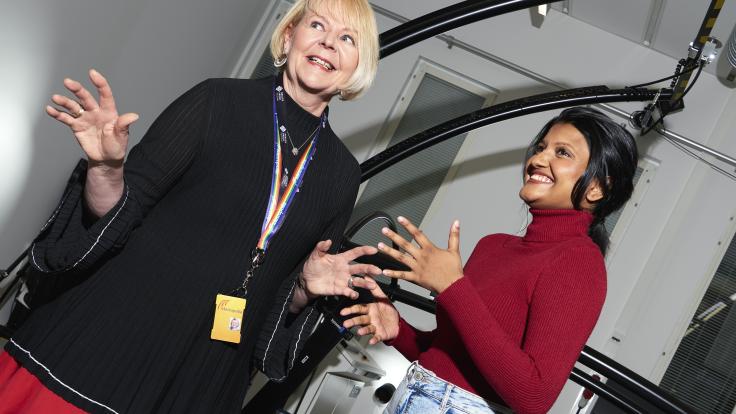 Opiskelija ja opettaja hymyilevät keskustelun lomassa