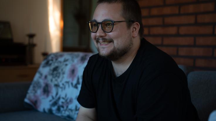 Opiskelija Akira poseeraa sohvalla