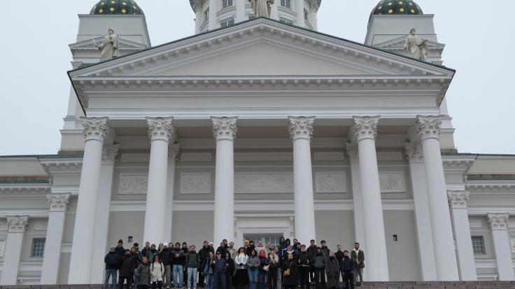Opiskelijoita Helsingissä kirkon edessä