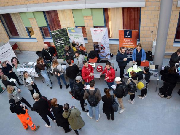 Students in the lobby of the Myyrmäki campus checking out the companies' stands.