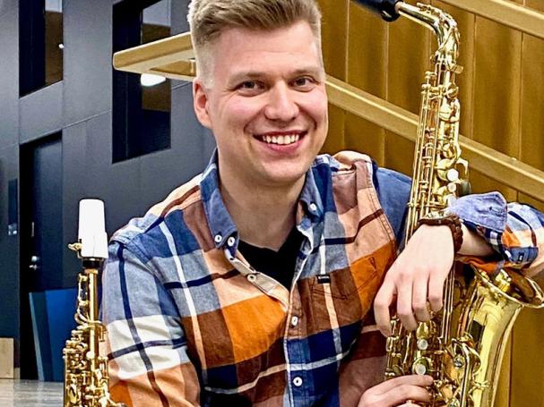 Samuli Nieminen istuu Soivan rappusissa soittimineen.