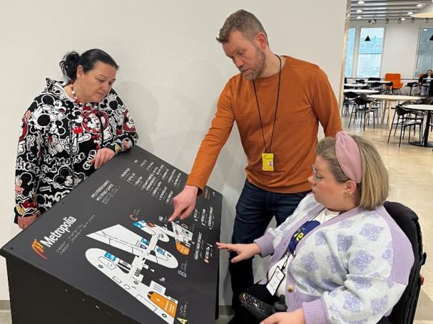 Three people looking at a campus map.