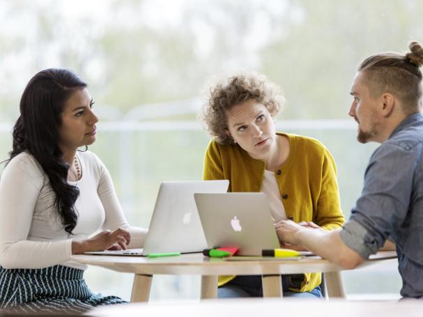 Three persons discussing.