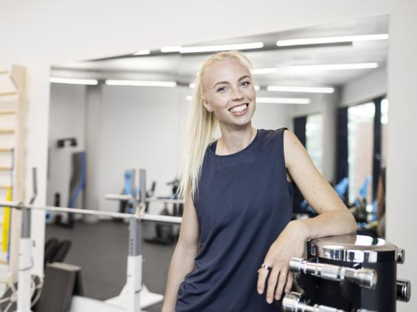 Urheilija poseeraa kuntosalilla