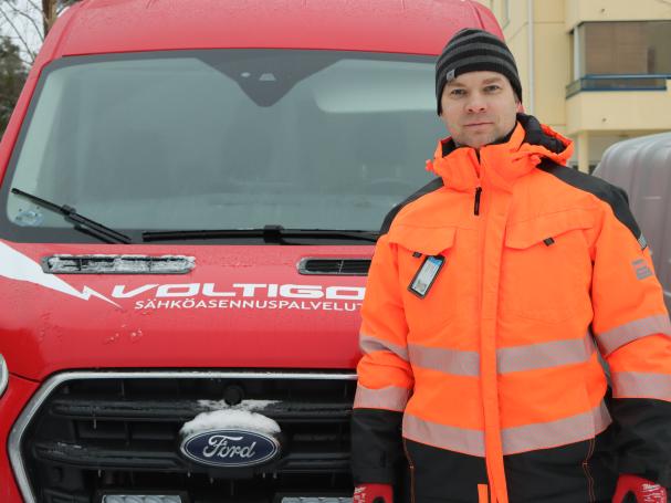 Voltigon työntekijä poseeraa auton edessä
