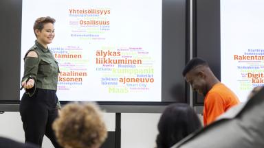 Henkilöitä esitysnäytön ympärillä