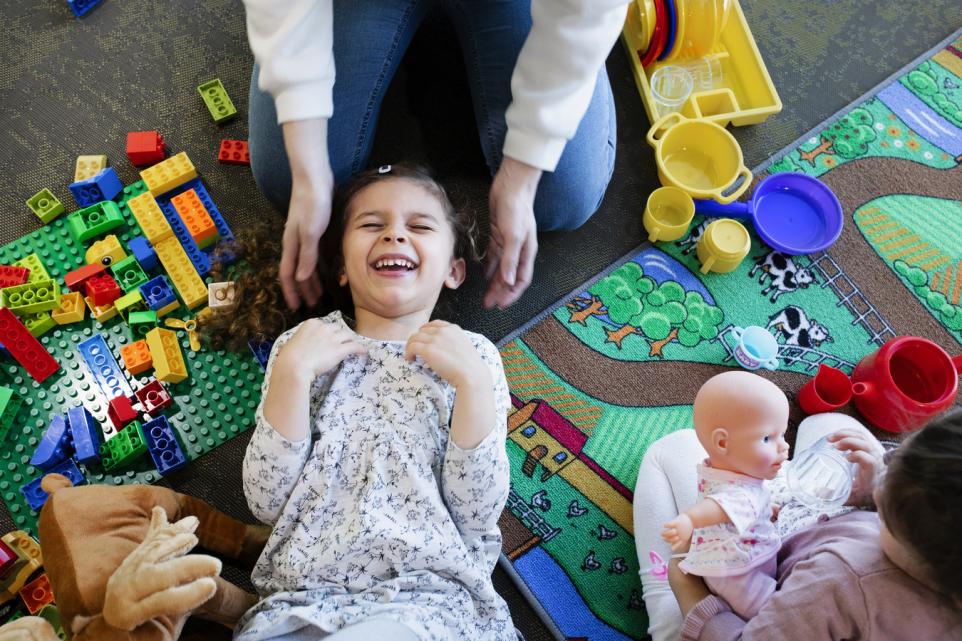 Happy child playing with an adult.