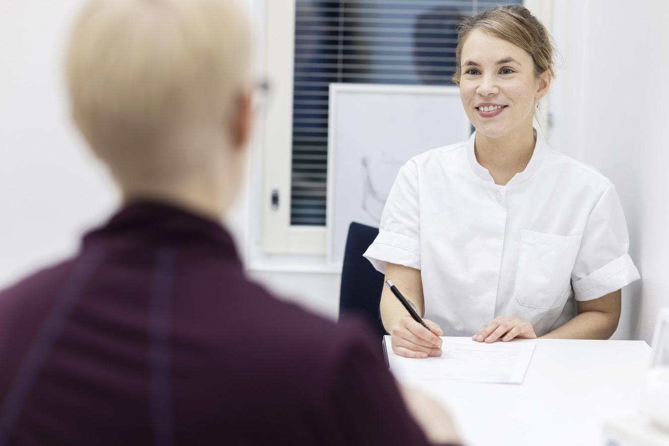 Seksuaaliterapeutti keskustelee asiakkaan kanssa pöydän ääressä.