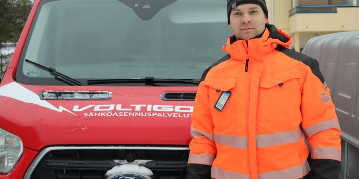Voltigon työntekijä poseeraa auton edessä